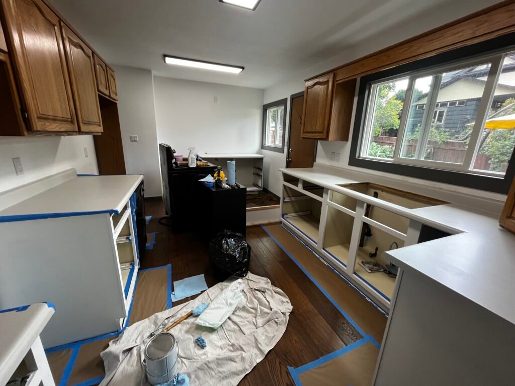 Kitchen renovation by Catalyst Home Improvements - Windows trimmed out, knockdown ceiling texture applied, walls painted, new lighting installed, new cabinet installed & countertops refinished. Cabinet door and drawers have been taken to the shop to be sprayed and cabinets are being painted